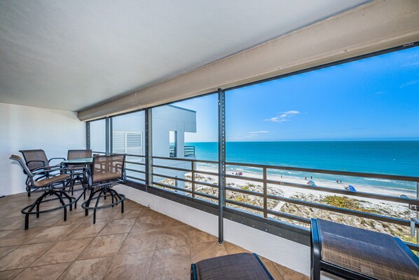 Un balcon avec vue sur la plage et l’océan.