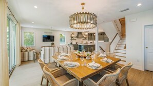 Comedor con una mesa de madera dispuesta para seis personas, rodeado de sillas de mimbre.
