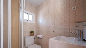 Un baño pequeño con inodoro, lavamanos y ventana.