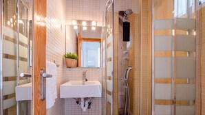 A modern bathroom with a shower, sink, and toilet.
