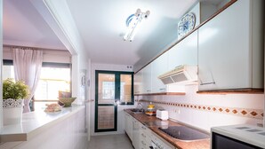 A modern kitchen with white cabinets, a granite countertop, and a built-in oven. - Sunset Malaga Apartments - PALM BEACH (Torremolinos)