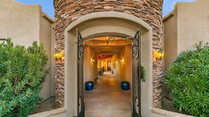 Un arco de piedra marca la entrada, con un camino que conduce a un edificio.