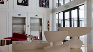 A modern interior with a red sofa, a table with a decorative bowl, and framed pictures on the wall. - UMA House by Yurbban South Beach (Miami Beach)