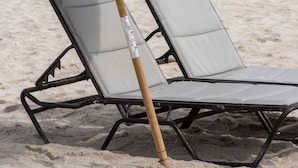 Two lounge chairs with a beach umbrella on a sandy beach. - UMA House by Yurbban South Beach (Miami Beach)