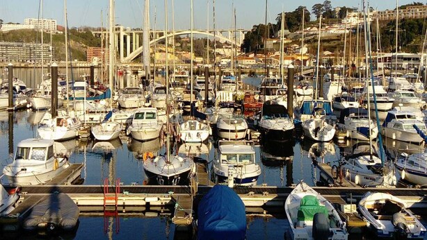 A marina with numerous boats docked, a bridge in the background, and a calm water surface. - CASA MIRA DOURO marina beach 5mnts on foot caves, Porto bridge 5mnts by car (Vila Nova de Gaia)