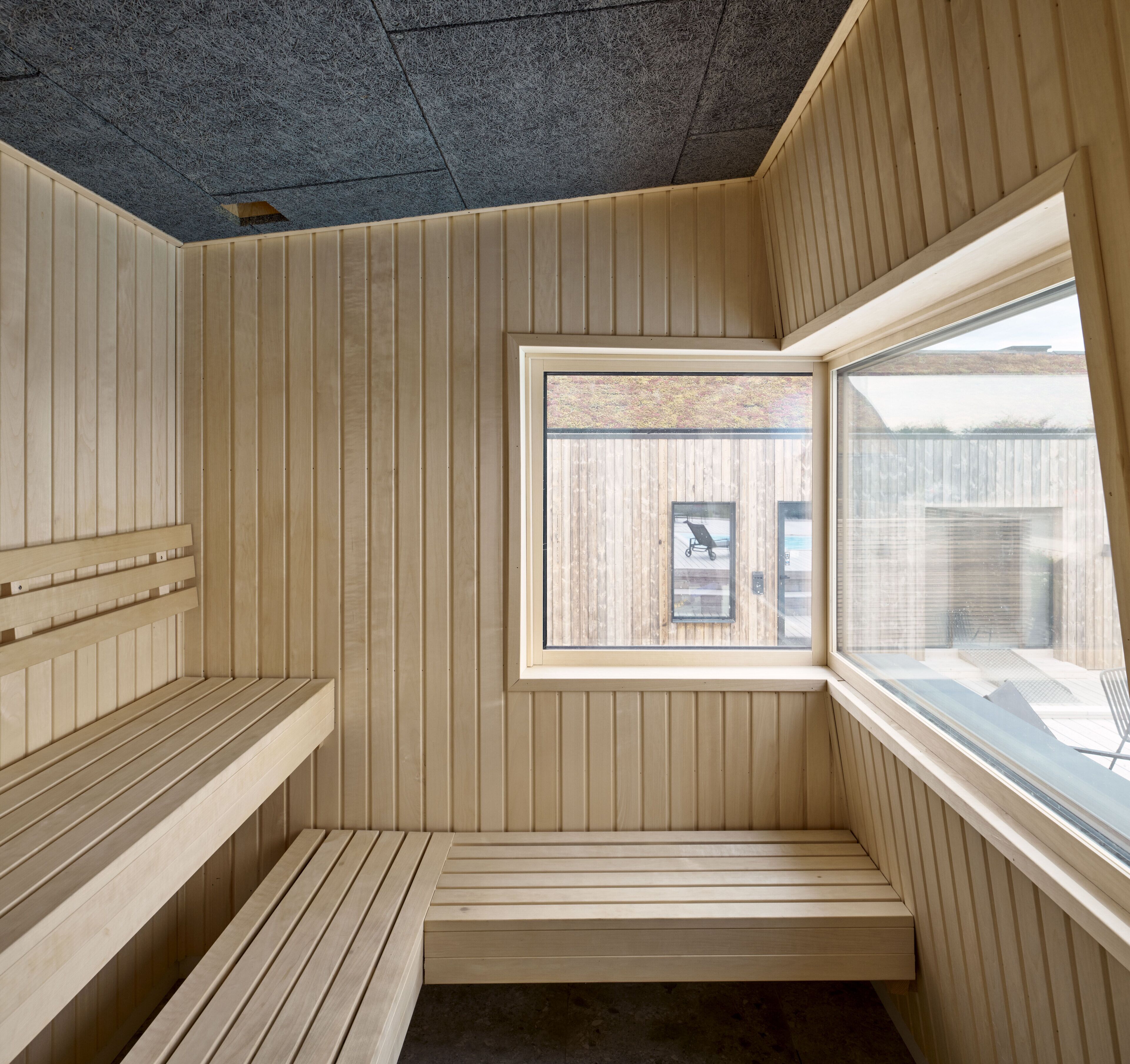 Un cuarto de sauna con bancos de madera y una ventana.