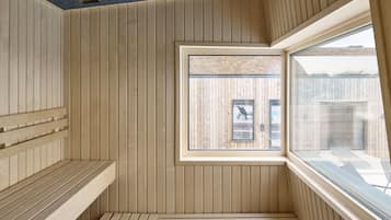 Un cuarto de sauna con bancos de madera y una ventana.