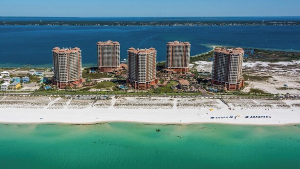 Un hotel de gran altura con vista a la playa, que cuenta con varios balcones y una zona de piscina.