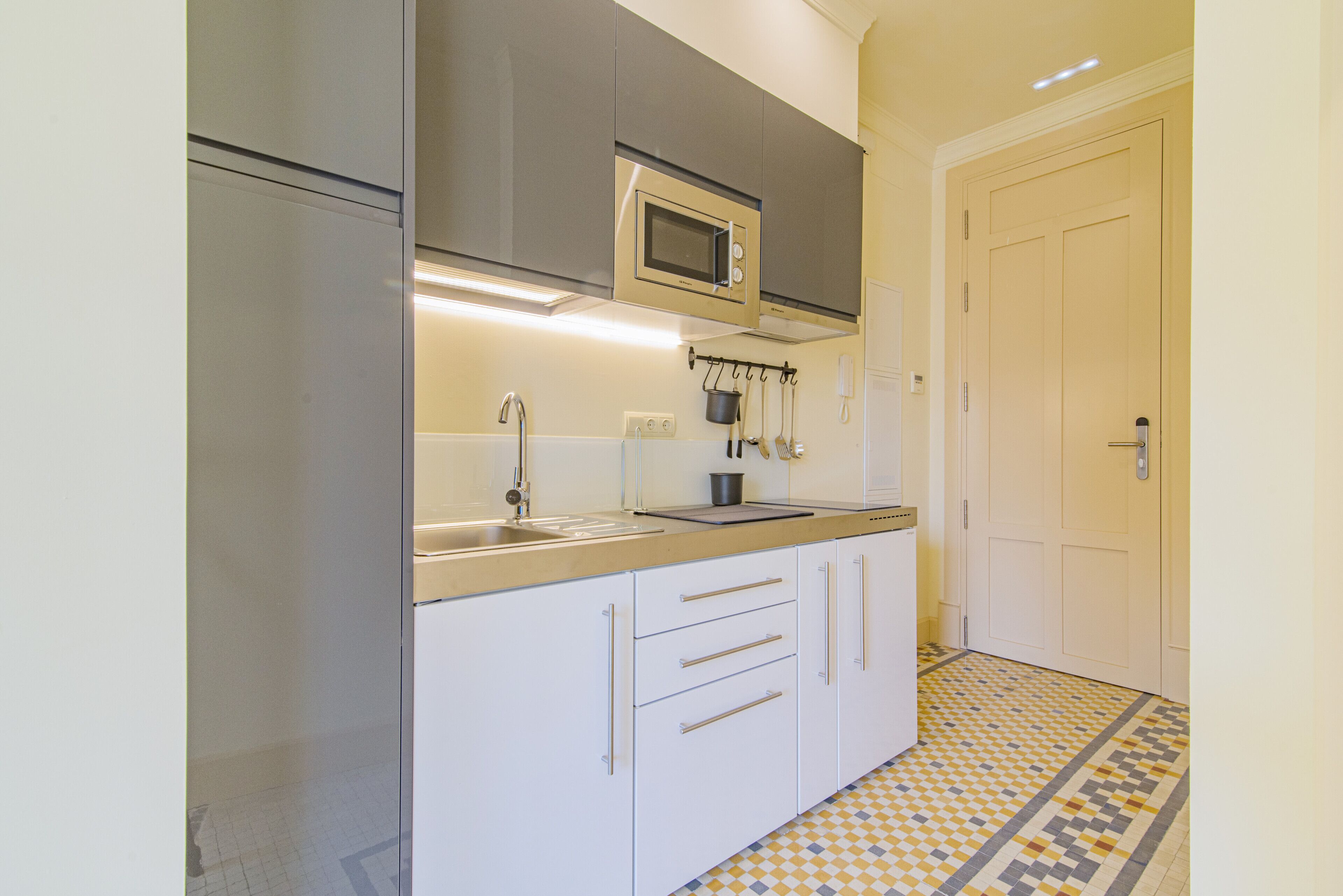 A kitchen with a microwave, sink, and cabinets.