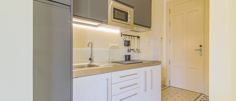 A kitchen with a microwave, sink, and cabinets.