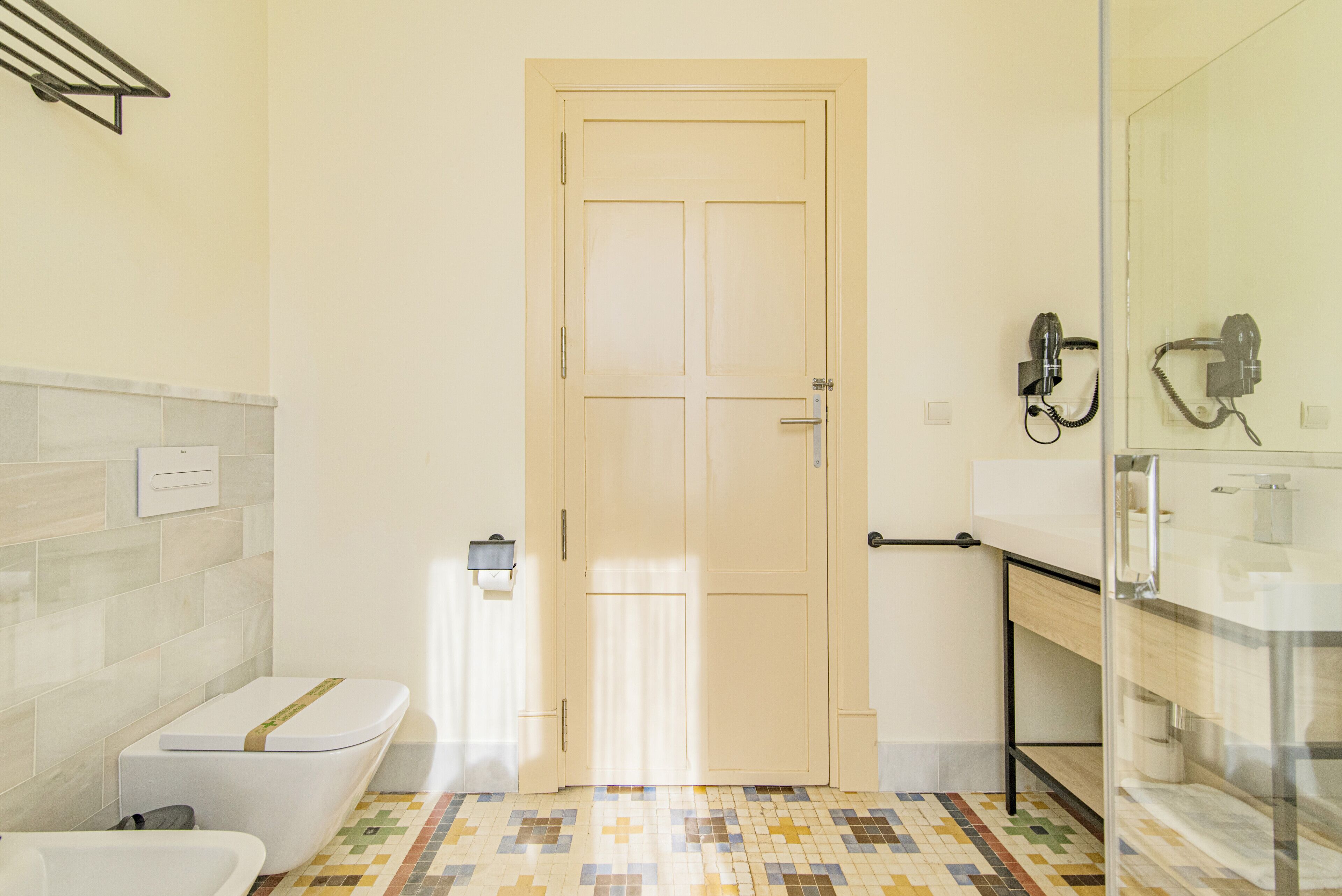 Une salle de bain comprenant des toilettes, un lavabo et un espace douche.