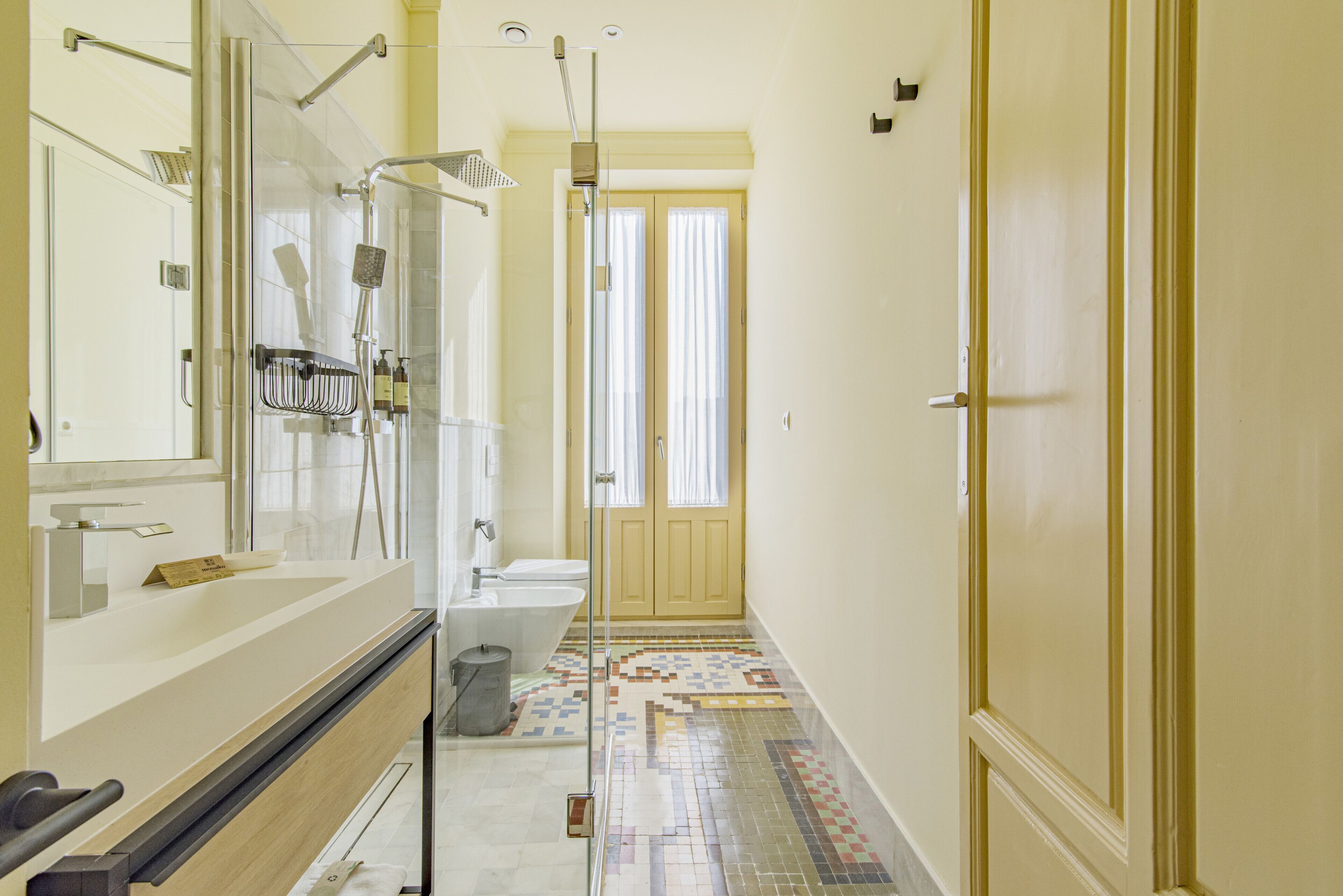 A modern bathroom with a glass shower enclosure, a bathtub, and a toilet.