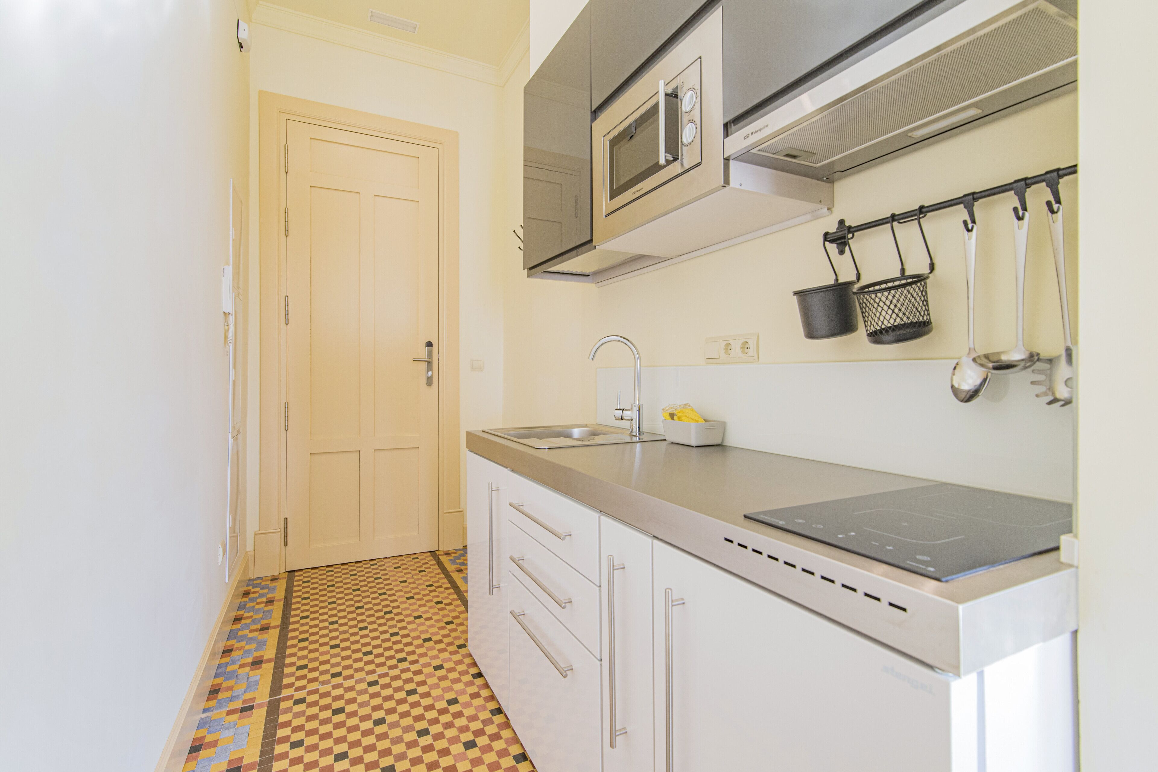 Una cocina con microondas, pileta y estufa.
