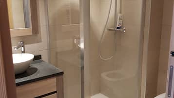 Bathtub, hair dryer, towels, toilet paper