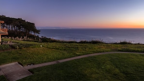 A coastal landscape with a grassy area, a pathway, and a view of the ocean. - Expansive Ocean Views-Prime Condo at Seascape! (Aptos)