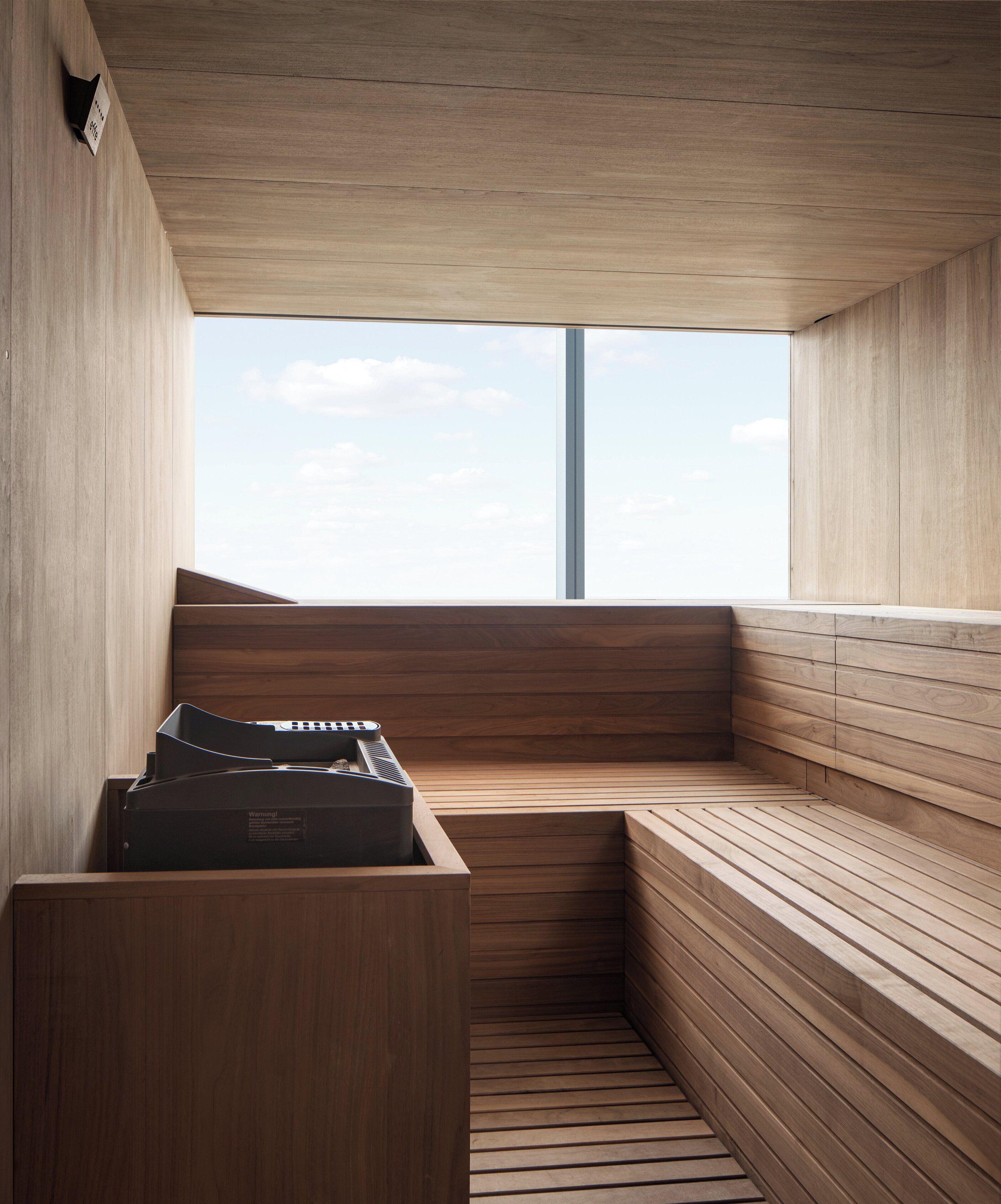 A sauna with wooden benches and a large window.