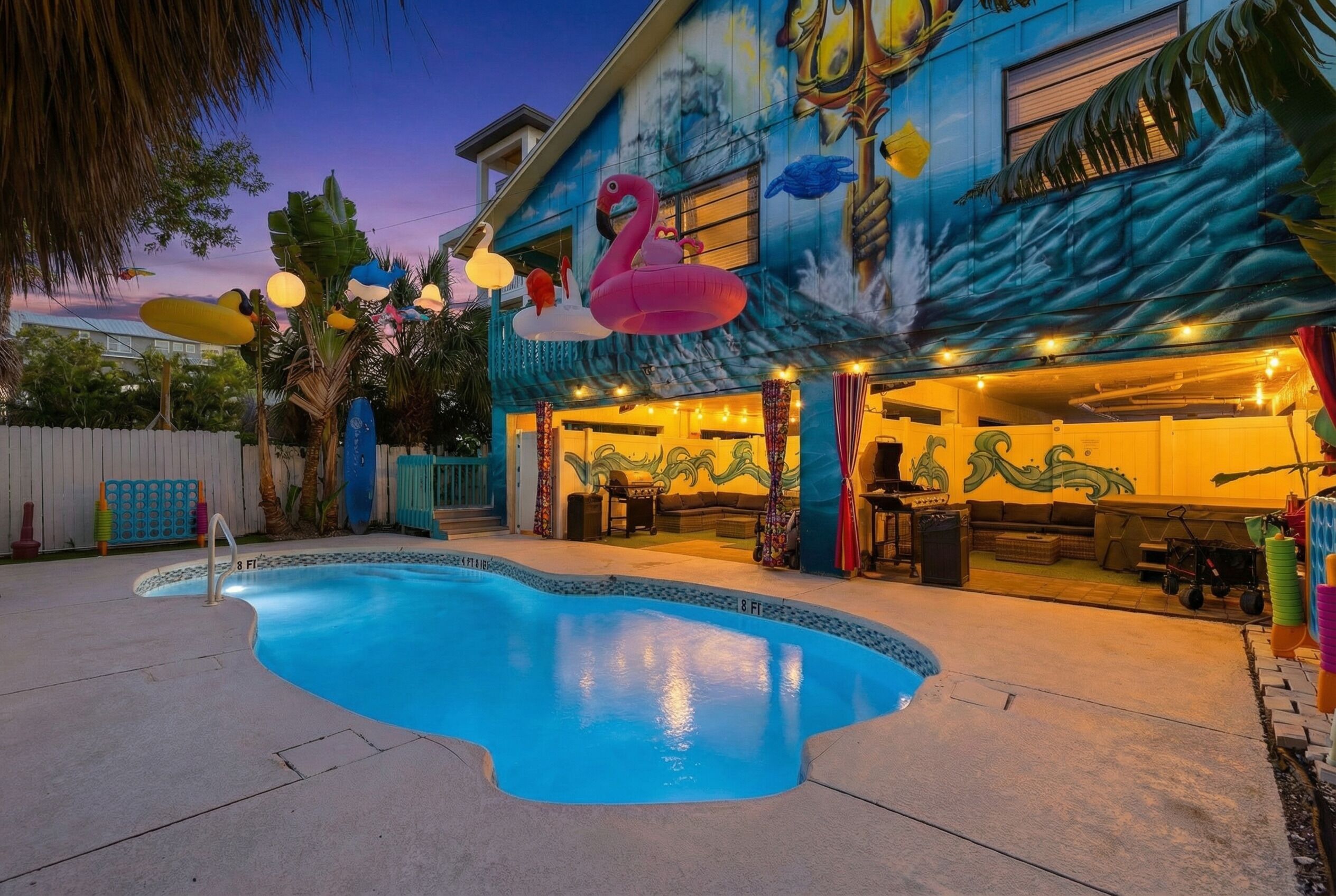 A swimming pool with a mural of a flamingo and a swan on the building.