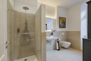 A modern bathroom with a glass-enclosed shower, a sink, and a toilet. - homie stay am schloss (Würzburg)