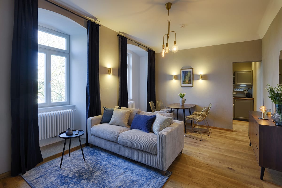 Un salon moderne avec un canapé, une table basse et un coin repas.