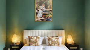 A bedroom with a bed, two nightstands with lamps, a painting above the bed, and a green wall. - homie stay am schloss (Würzburg)