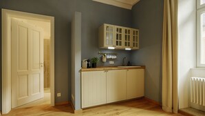 A kitchen with wooden cabinets, a countertop, and a window with curtains. - homie stay am schloss (Würzburg)