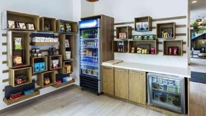 Una kitchenette con estantes de madera, un refrigerador y un congelador pequeño.