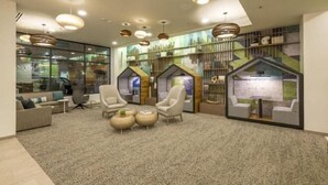 A modern lobby with comfortable seating, a fireplace, and a large window overlooking the city. - Element Colorado Springs Downtown (Colorado Springs)