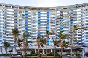 A multi-story hotel with a modern architectural design, featuring a series of balconies and a central atrium.