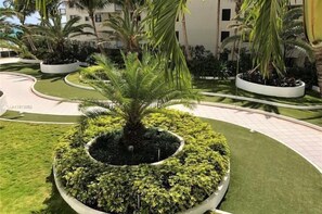 A landscaped area with palm trees and a circular garden bed.