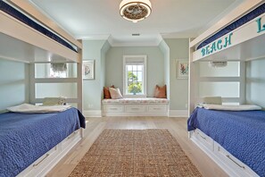 Relax in this stylish bedroom with a central seating area and two comfortable beds.