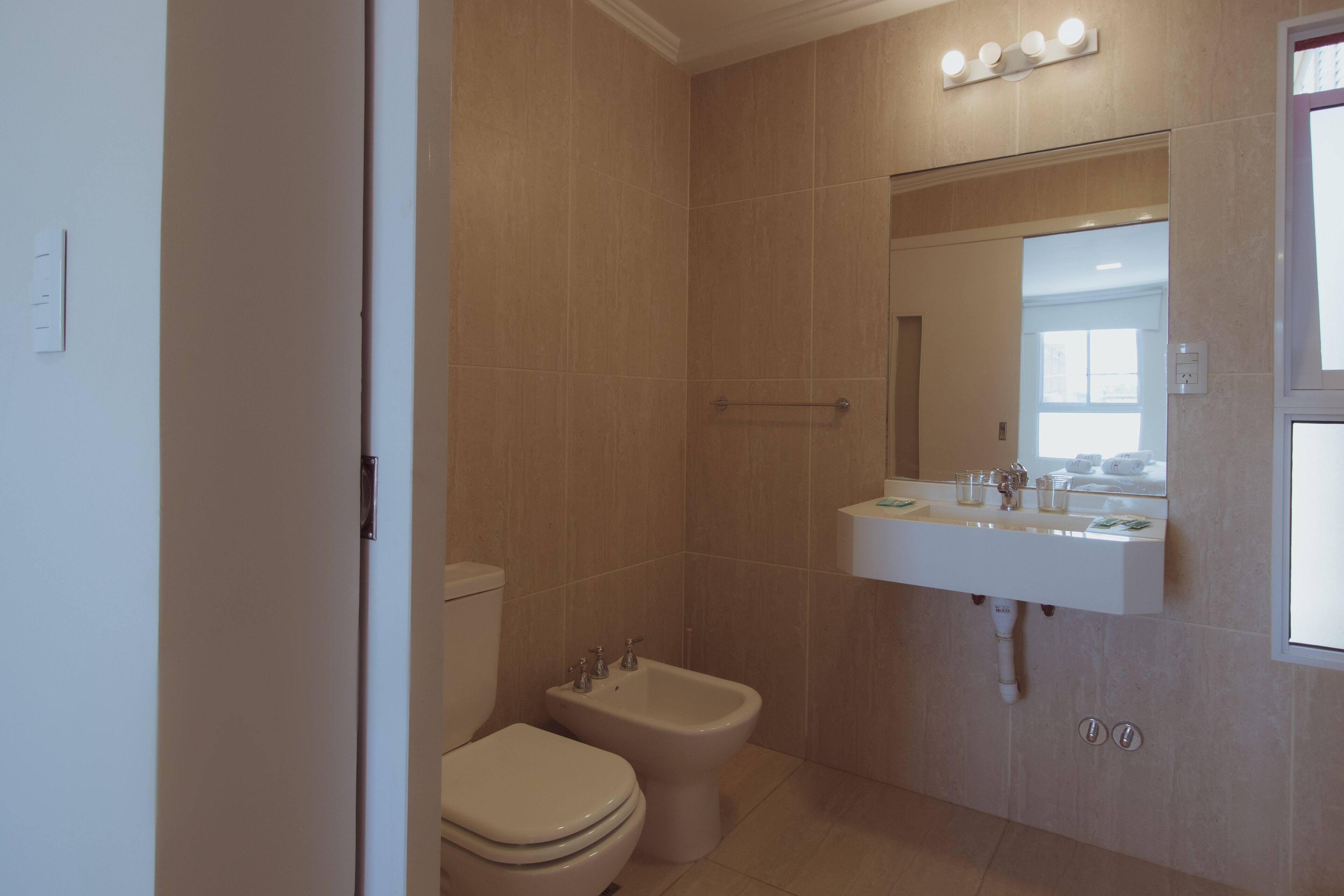 A bathroom with a toilet, bidet, and sink.
