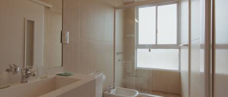 A modern bathroom with a large sink, toilet, and shower.
