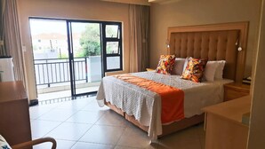 Une chambre d’hôtel avec un lit, une table de chevet, une chaise, une fenêtre avec des rideaux et une vue sur l’extérieur.