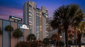Un hôtel dont la façade porte une enseigne indiquant « Courtyard Springhill Suites » et « Breakers ».