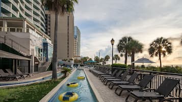 A pool area with lounge chairs and a water slide.