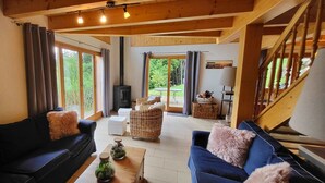 A cozy living room with a fireplace, two sofas, and a dining table. - Chalet - Calm, comfort and splendid view (Mayens de chamoson)