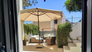 Eine Terrassenanlage mit Gartenmöbeln, einer Pergola und Blick auf die umliegende Landschaft.
