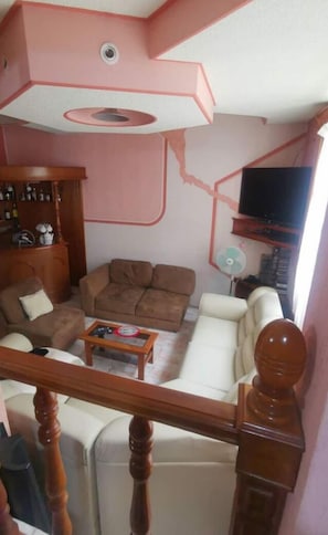 A living room with a sofa set, a coffee table, and a television.