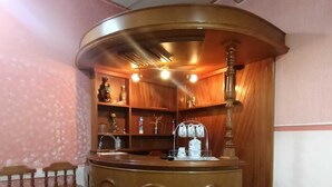 A corner reception area with a wooden counter, two stools, and a shelf with various items. - Beautiful house in private, a few minutes from downtown!!!! (Oaxaca de Juárez)