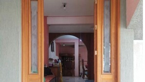 A wooden door leading to a tiled hallway with a bench and a trash bin. - Beautiful house in private, a few minutes from downtown!!!! (Oaxaca de Juárez)