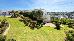 A residential building with a pool, surrounded by well-maintained gardens and a clear view of the cityscape. - Blue Sky Condo with Ocean&Pool view by Be Cherish (Albufeira)