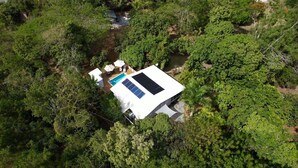 A house surrounded by dense greenery, with a swimming pool and solar panels on the roof. - Villa Valeria - An eco hideaway with all the modern luxuries (Cabo Rojo)