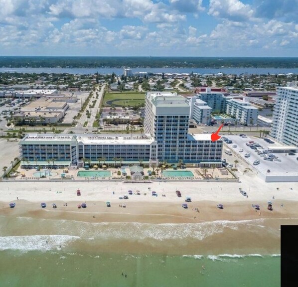 A coastal hotel with multiple buildings, a beach, and a view of the ocean. - Beautiful OCEANFRONT 1 Bedroom Condo - Open Pools (Daytona Beach)