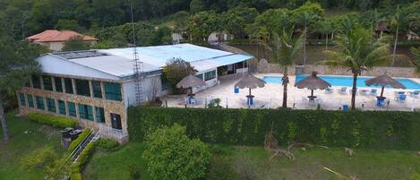 A building with a blue roof, a swimming pool, and outdoor seating.