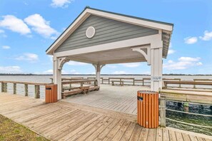 A wooden pier with a covered seating area, benches, and trash bins. - Chic Waterfront Retreat | Walk Score 100 + Kayaks (Swansboro)