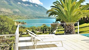 A terrace with a view of a mountain and a lake. - Seawave Villa (Καραβαδος)