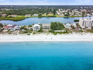Oversigtsbillede af et kystområde med strand, vand og boligbygninger.