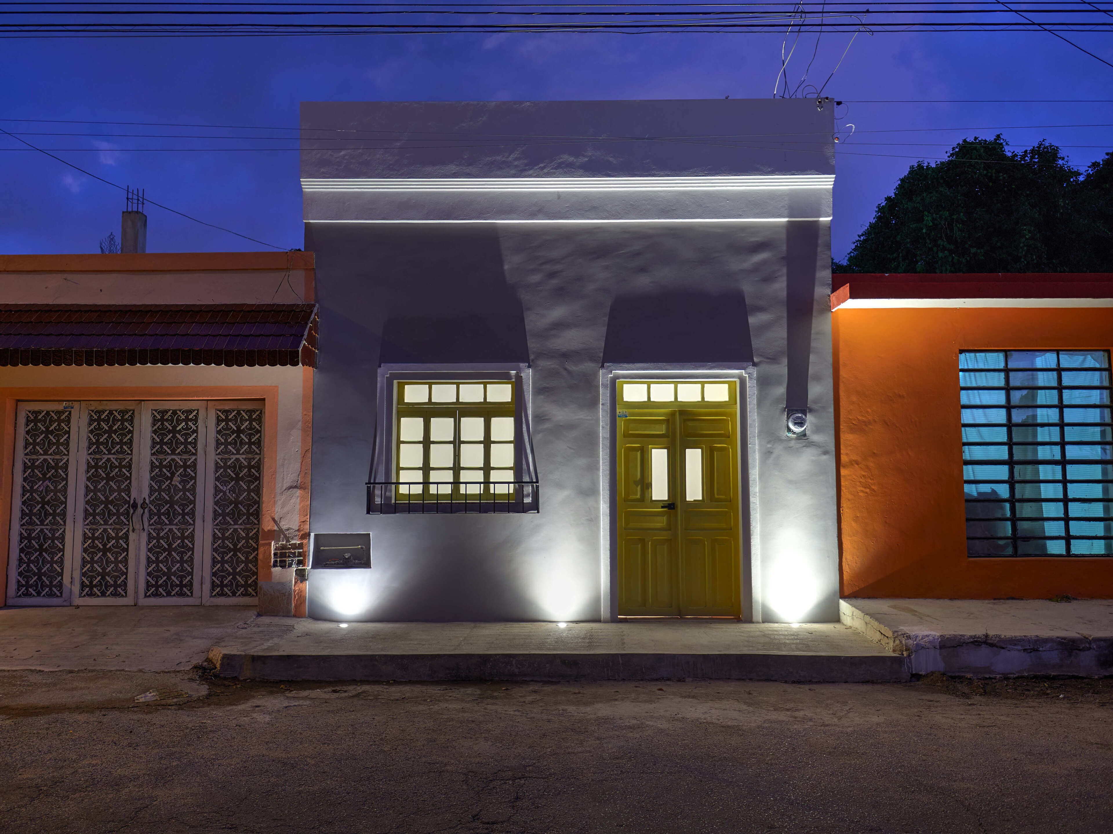 A building with a central door, two windows, and a small balcony.