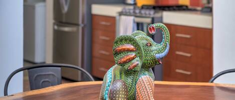 A dining table with a colorful elephant sculpture.