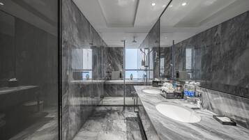 A modern bathroom with a glass-enclosed shower, two sinks, and a large mirror.